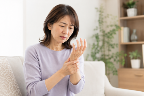 手にしびれを感じる女性
